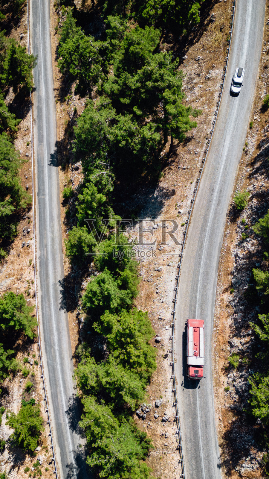 林地弯弯曲曲的柏油路，山区消防车行驶照片摄影图片