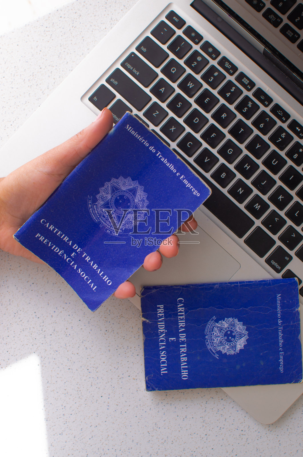 巴西工作卡。翻译-巴西联邦共和国，劳工部。巴西工作卡在笔记本电脑前，说明法律文件和就业市场之间的关系照片摄影图片