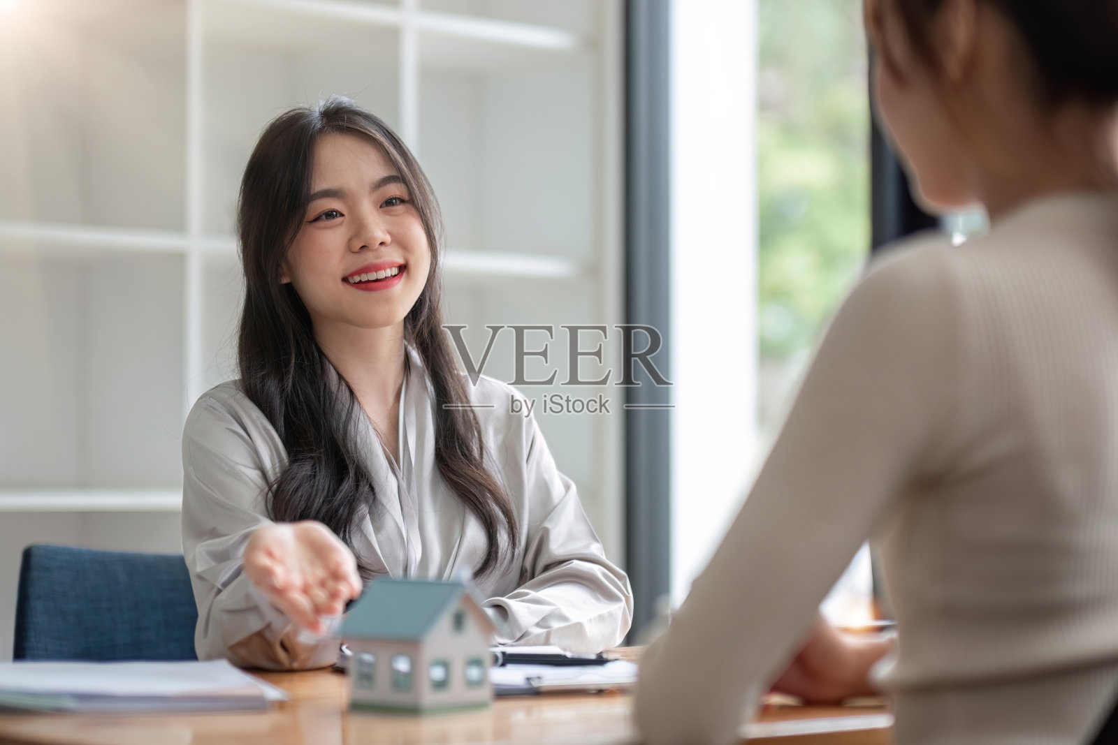 房地产经纪人讨论购房协议的条款，并要求客户签署文件，使合同合法，房屋销售，租赁，抵押和房屋保险。照片摄影图片