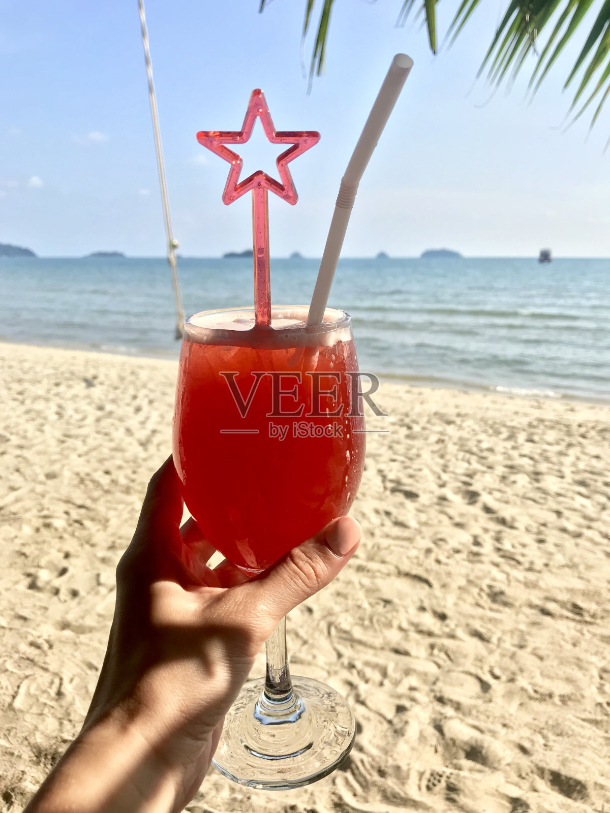 手里拿着红色鸡尾酒照片摄影图片