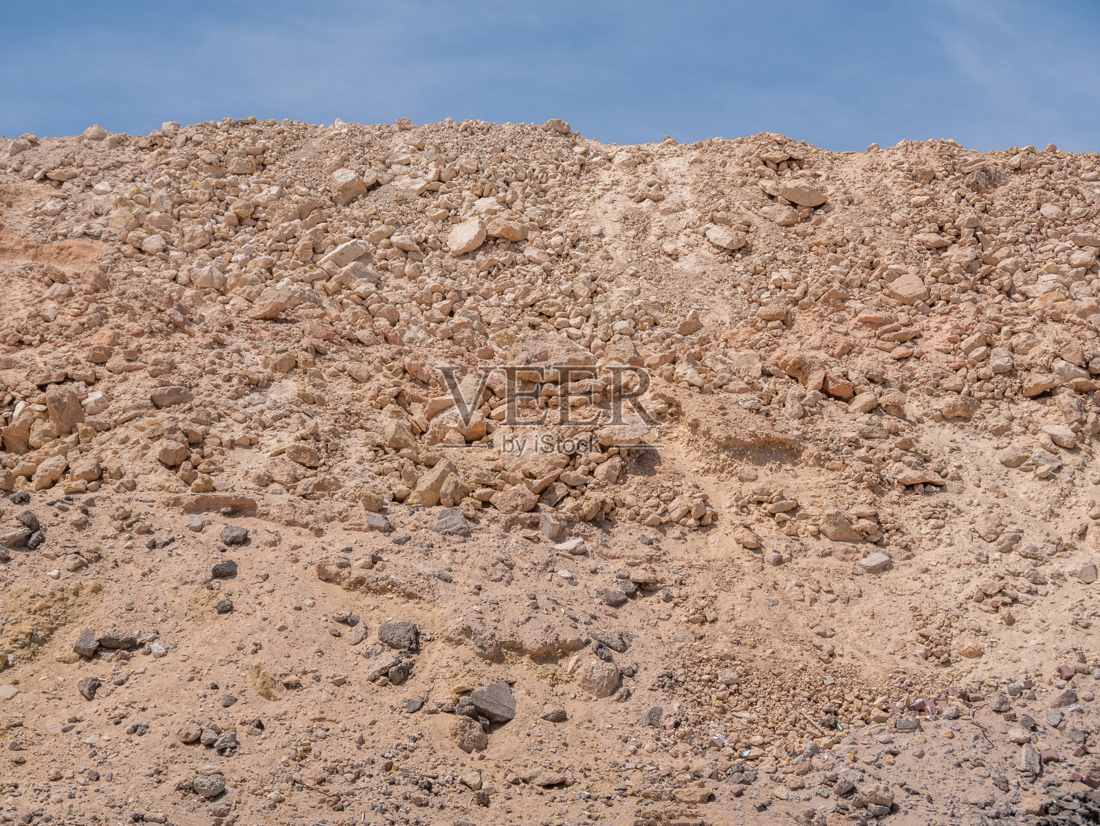 阳光明媚的景色，在北非的一个炎热的岩石沙漠。石山映衬着蔚蓝的天空。照片摄影图片
