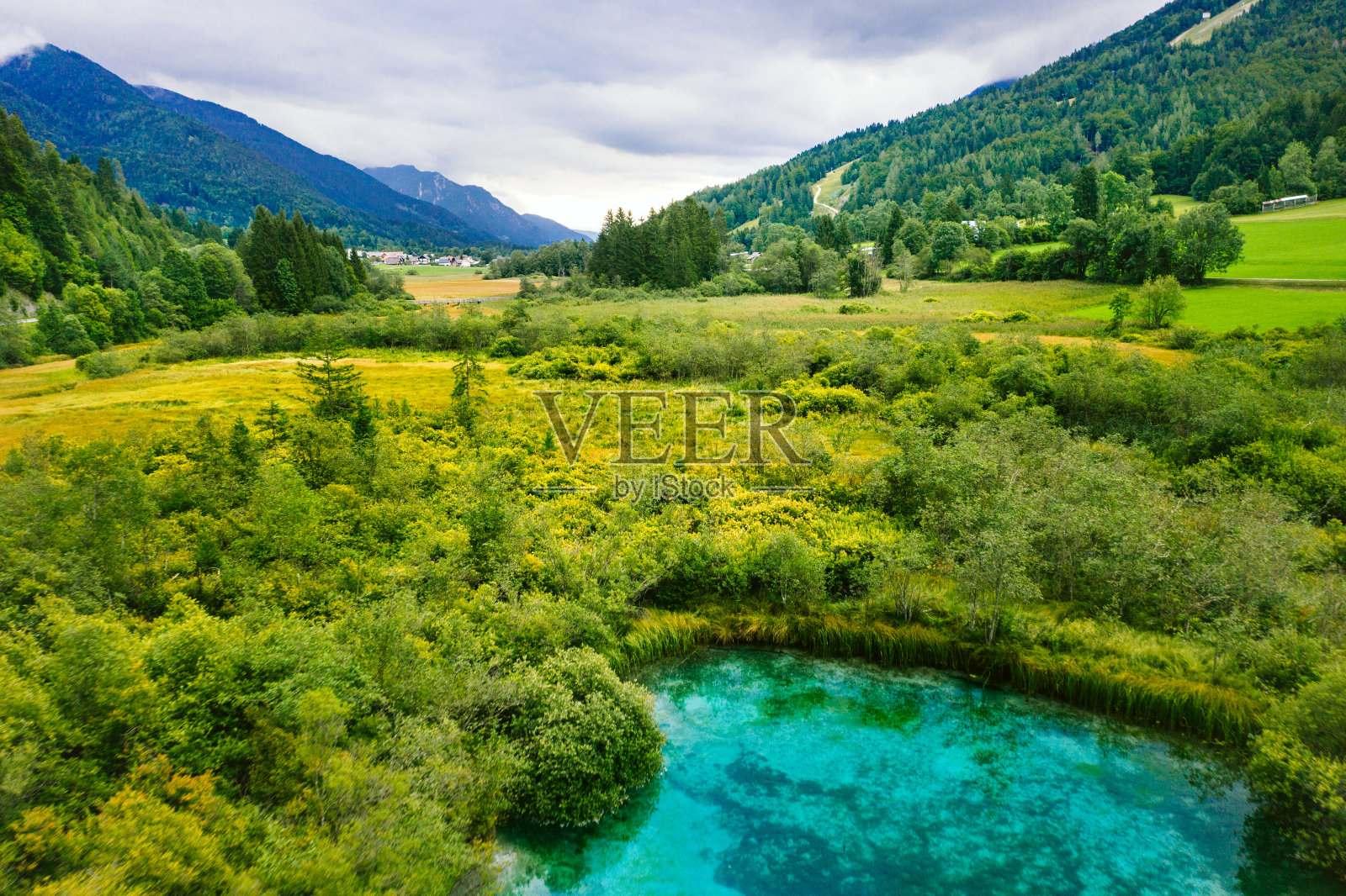 宁静的早晨，泽伦西湖被森林、绿色草地和群山环绕。照片摄影图片