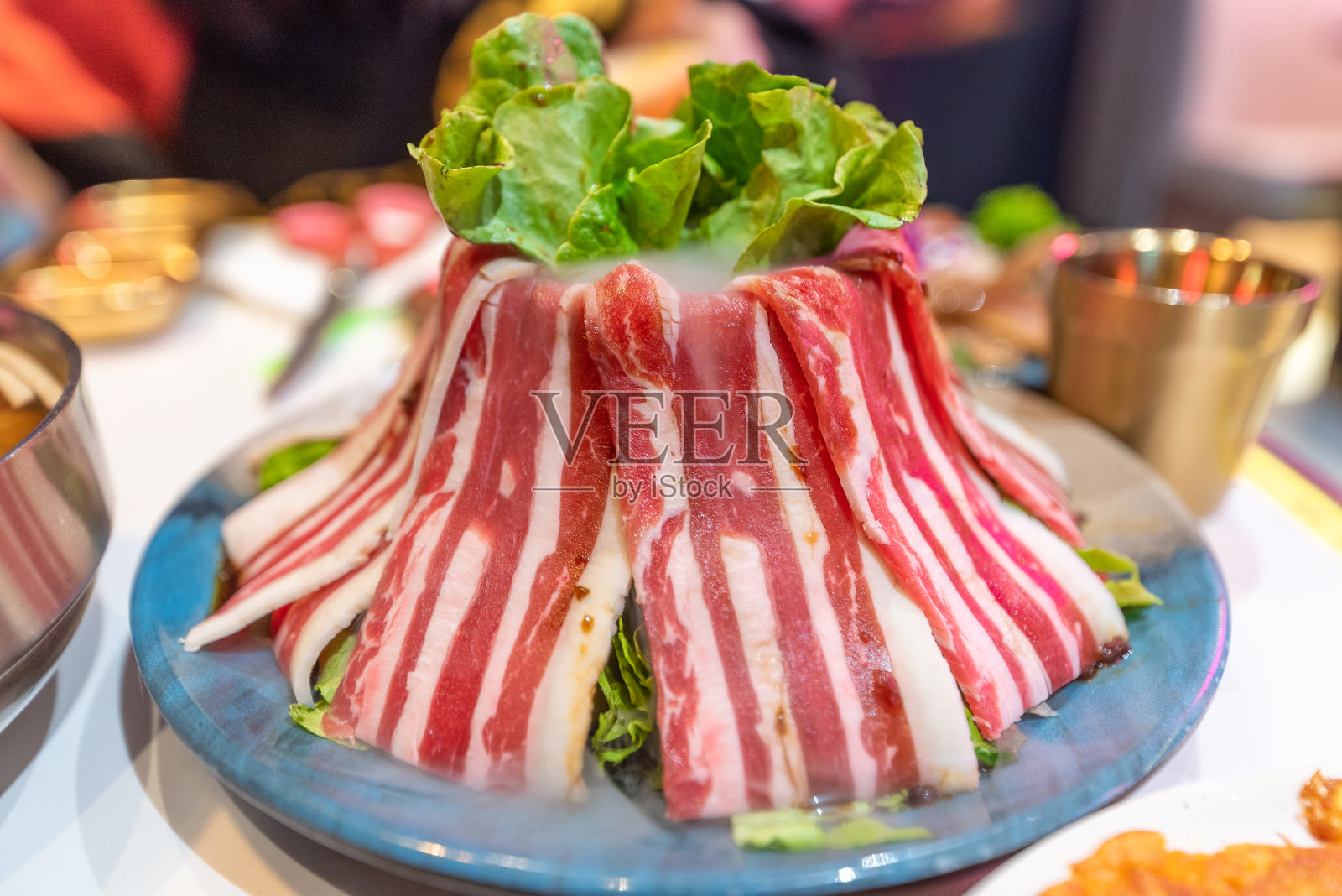 放在盘子里堆成火山形状的生肥牛照片摄影图片