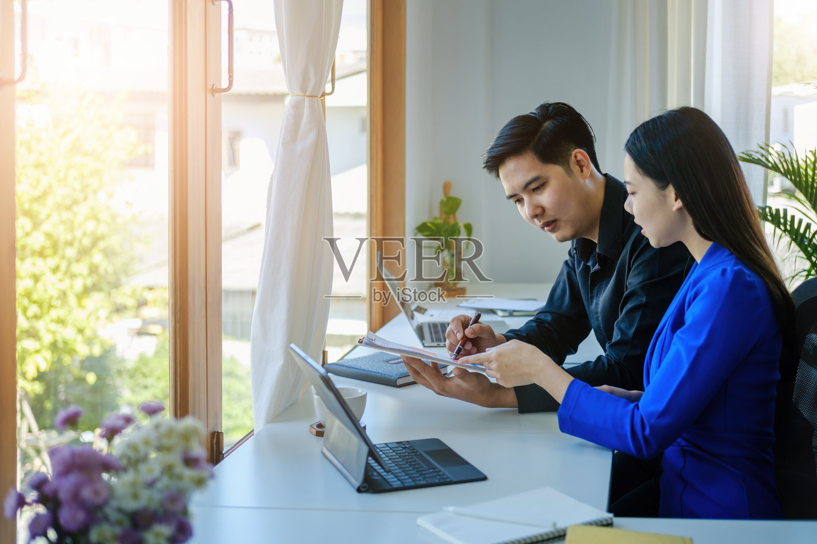 团队合作理念，咨询，男经济学家拿着笔指着预算、财务和投资文件，在会议室与女顾问讨论和规划财务。照片摄影图片