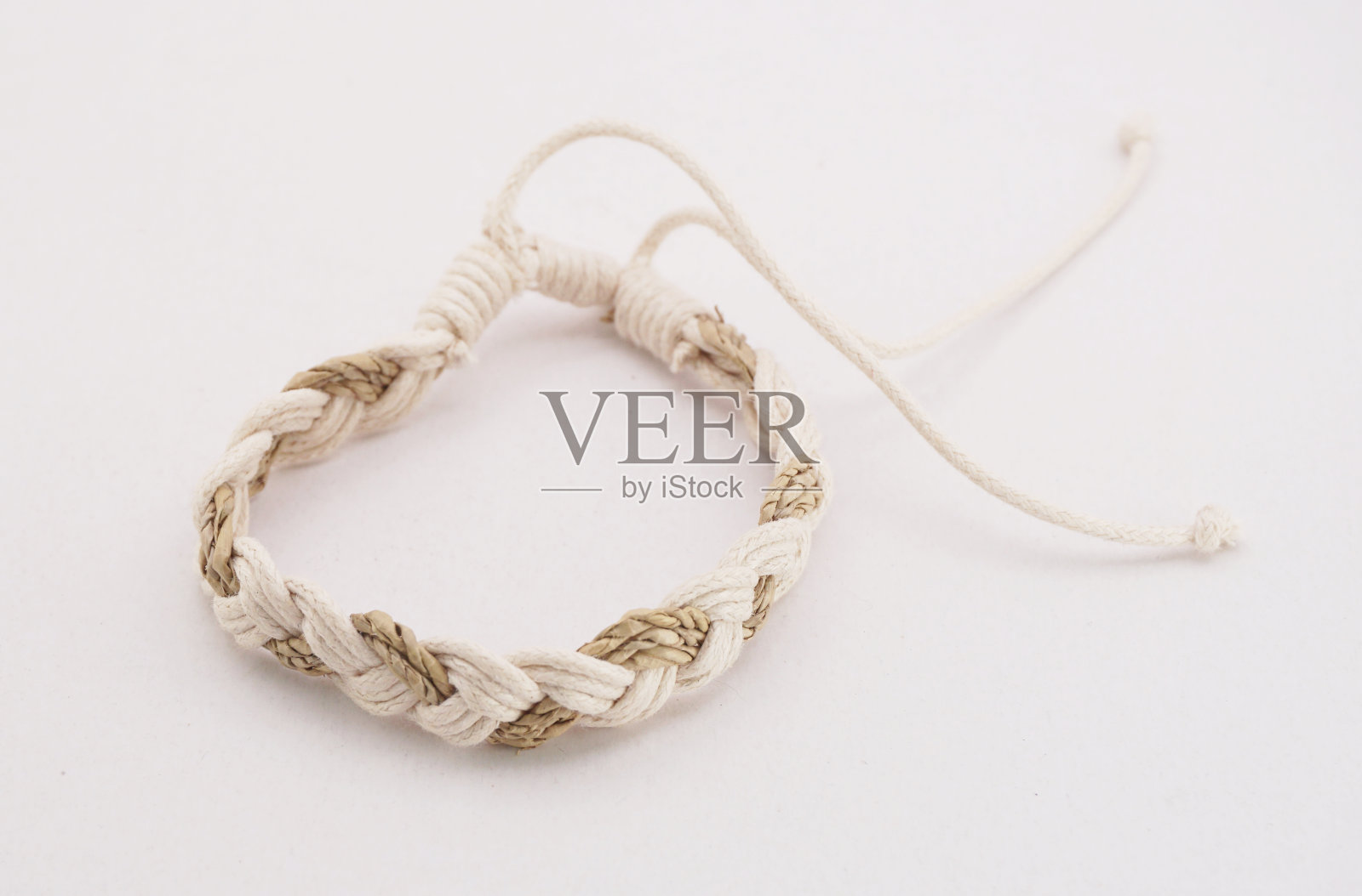 一个孤立的种族手镯，白色背景。这手镯是用各种绳子制成的照片摄影图片