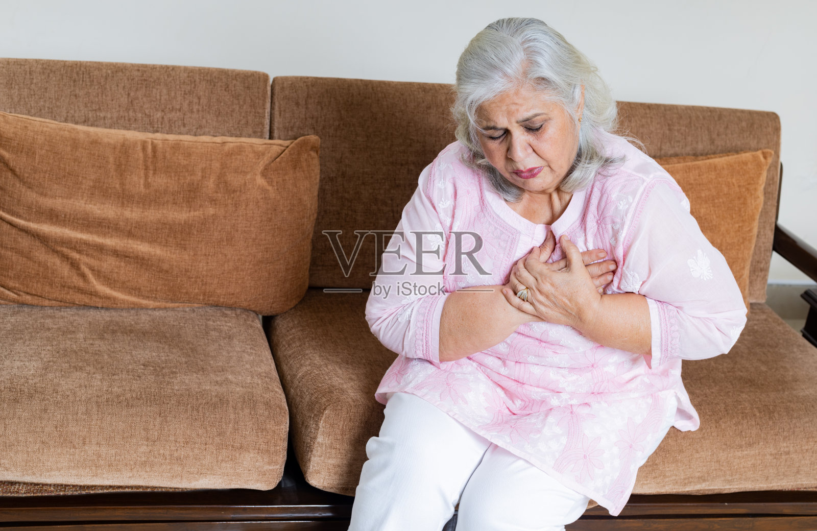 一位老年妇女因心脏病发作手放在胸口疼痛，照片摄影图片