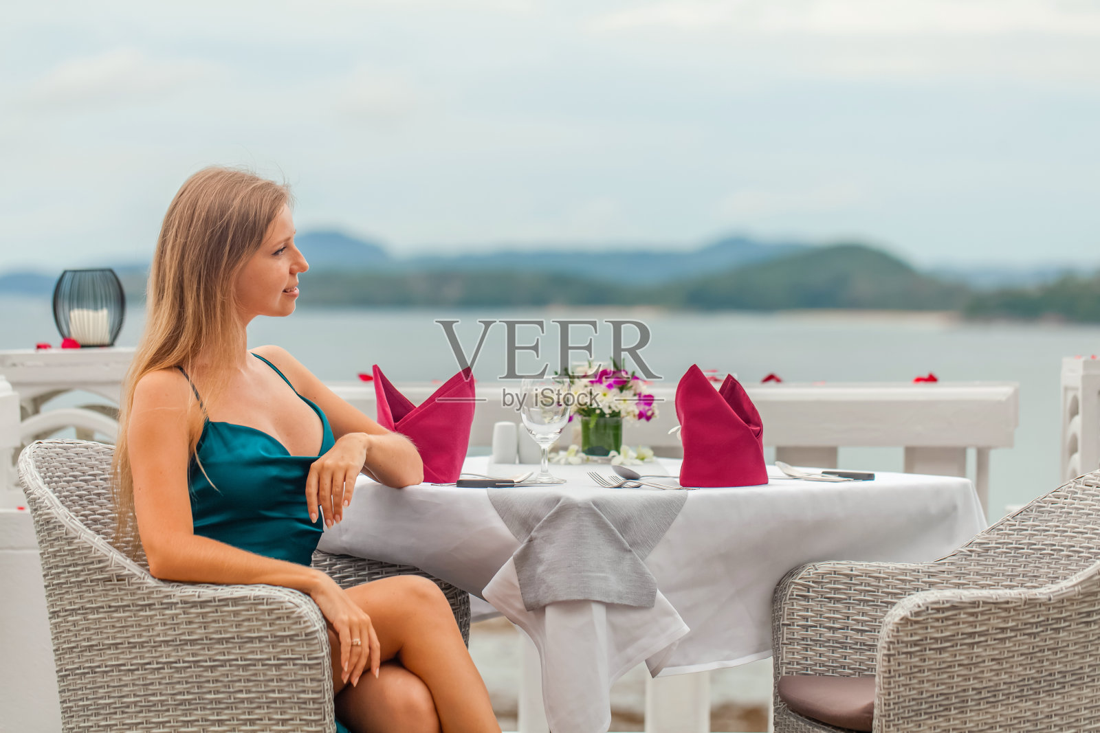 美丽的年轻女子穿着优雅的晚礼服在豪华酒店的餐厅照片摄影图片