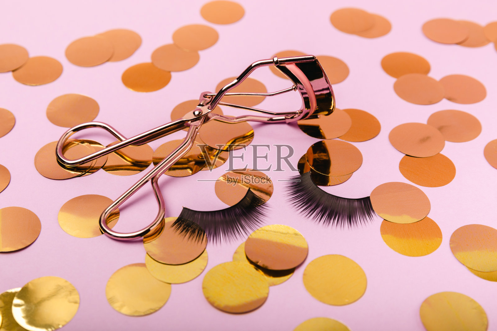 睫毛夹用于背景上的睫毛。睫毛妆的基础产品。睫毛卷曲工具。化妆。美concept.Close-up。照片摄影图片