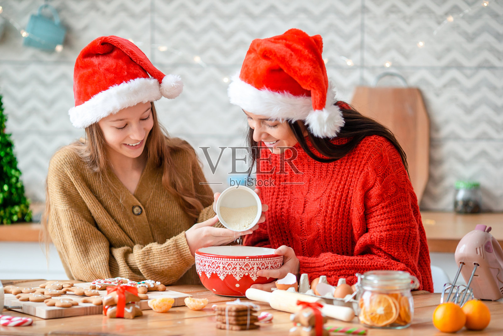 幸福家庭的母亲和女儿为圣诞节烤饼干照片摄影图片
