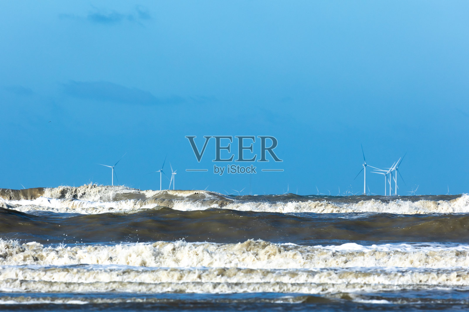 海上风车公园在暴风雨的北海与浪花漂移的波浪照片摄影图片