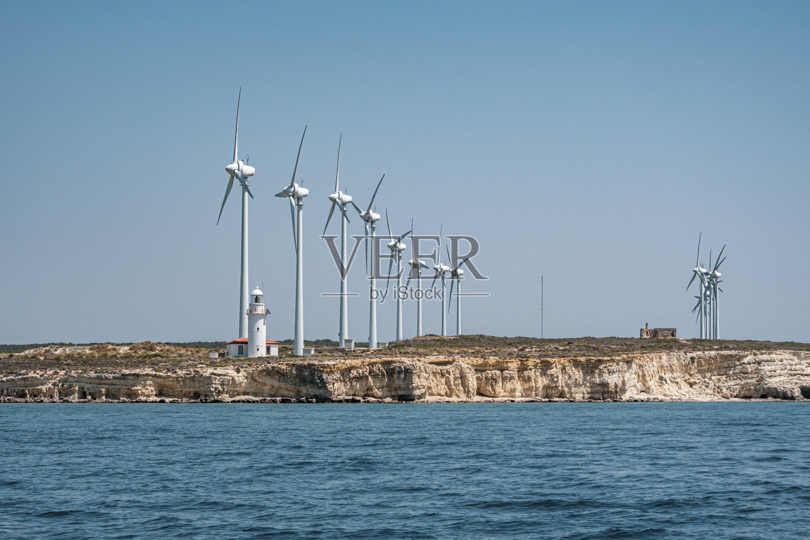 风力发电机和灯塔。照片摄影图片