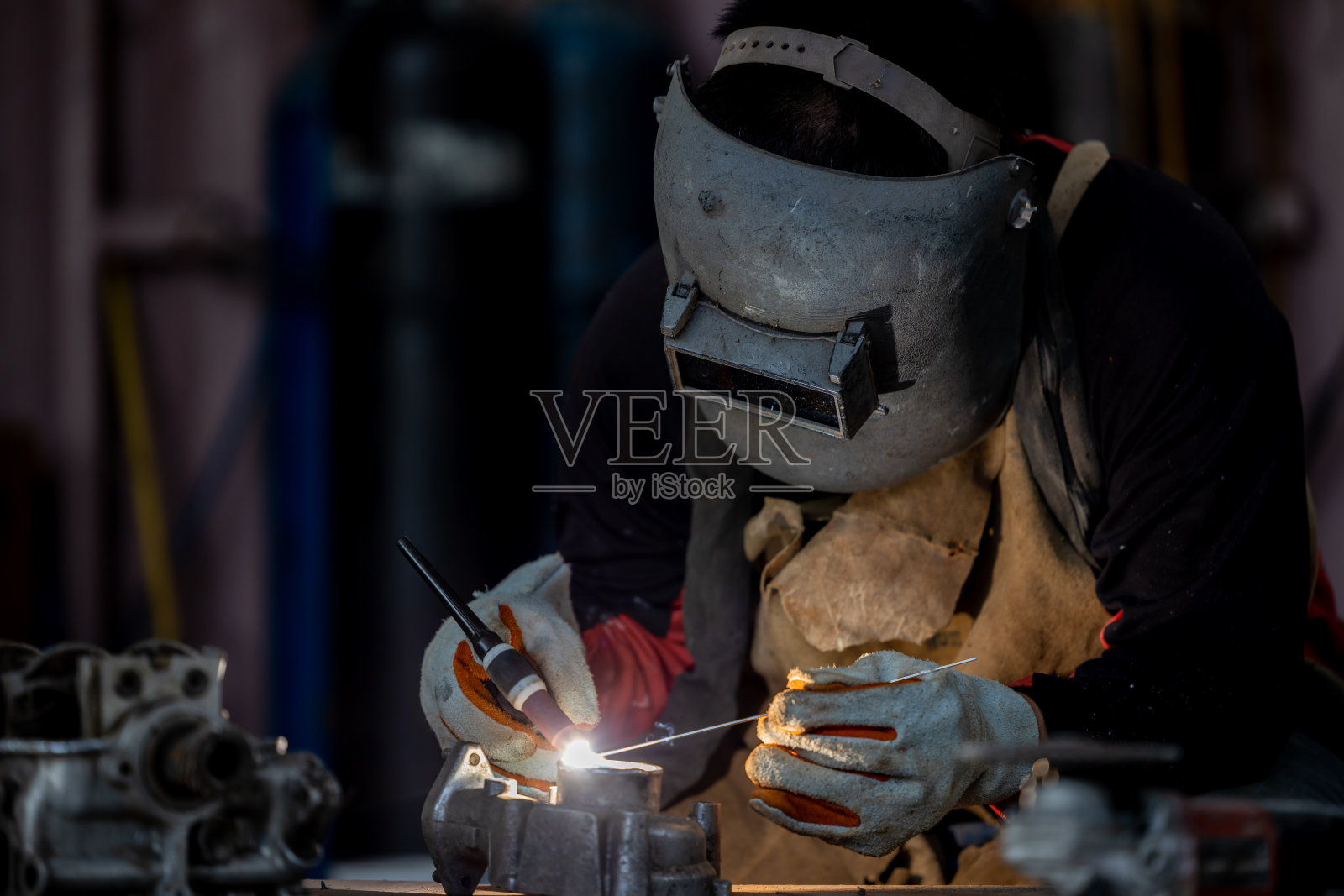 焊工在面罩焊用氩弧焊不锈钢，工业工人在工厂焊接钢结构，焊工正在焊接钨惰性气体。照片摄影图片