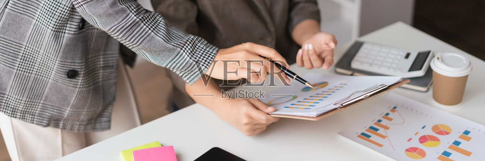 两个女商人一起阅读财务文件，集思广益地计划新的商业项目照片摄影图片