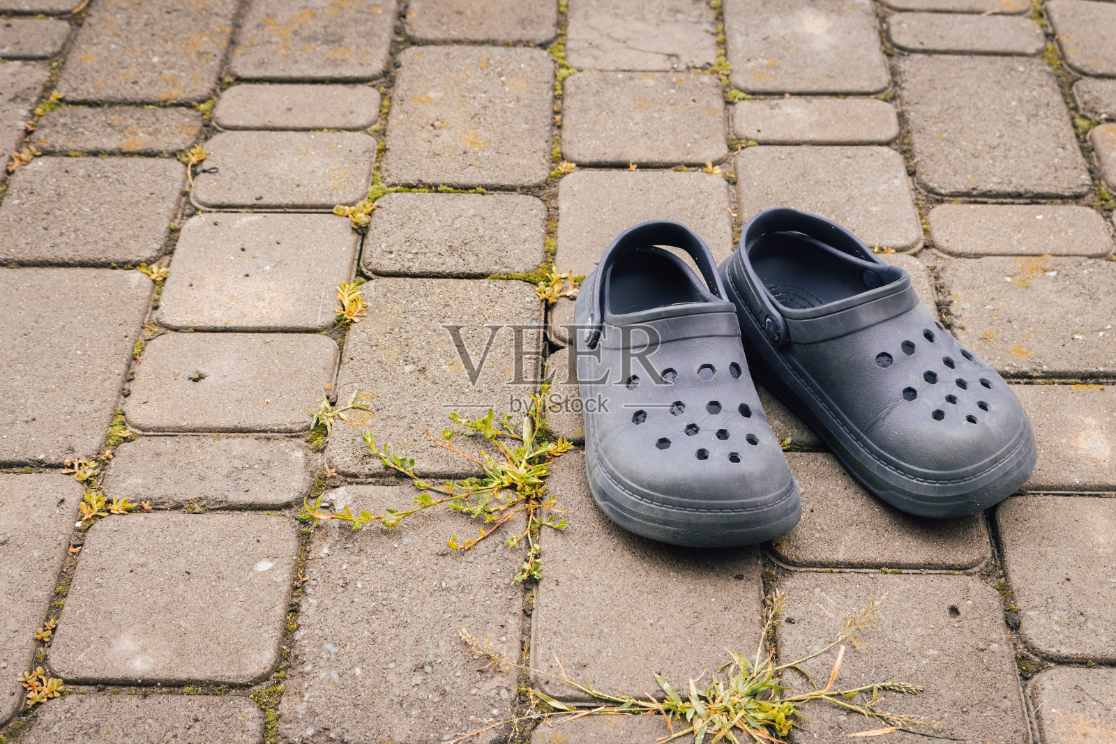 一双橡胶凉鞋。孩子们穿人字拖。人行道上的蓝鞋。旅行配件。现代的拖鞋。现代时尚。舒适的鞋子。儿童服装。照片摄影图片