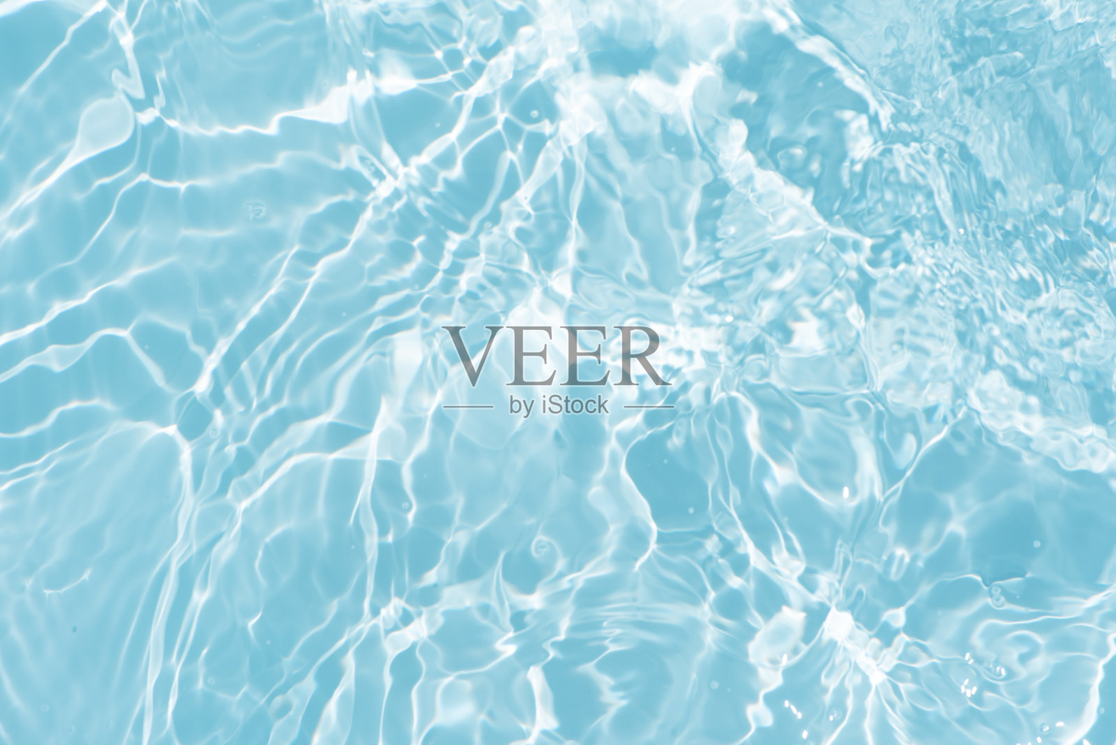 蓝蓝的水面上泛起涟漪。散焦模糊透明蓝色透明平静水面纹理与飞溅和气泡。水波与闪亮的图案纹理背景。照片摄影图片