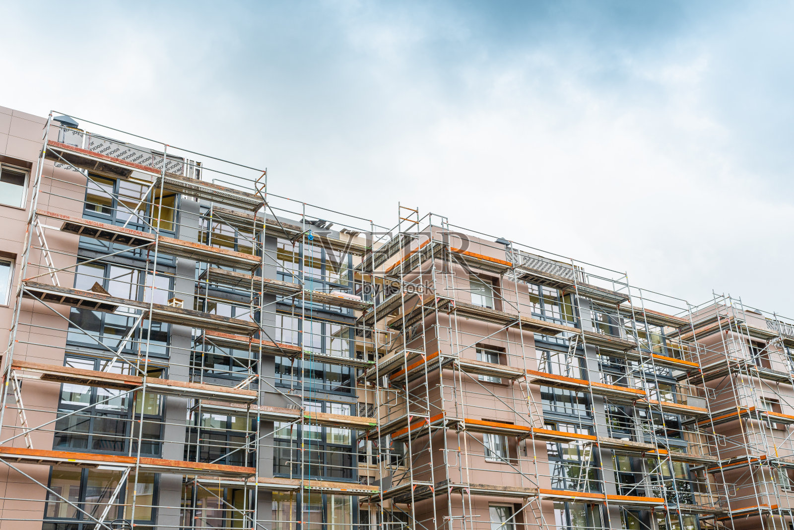 正在施工的高层建筑有脚手架。多层建筑外立面翻新时的脚手架。Telsiai,立陶宛05-31-2022。照片摄影图片