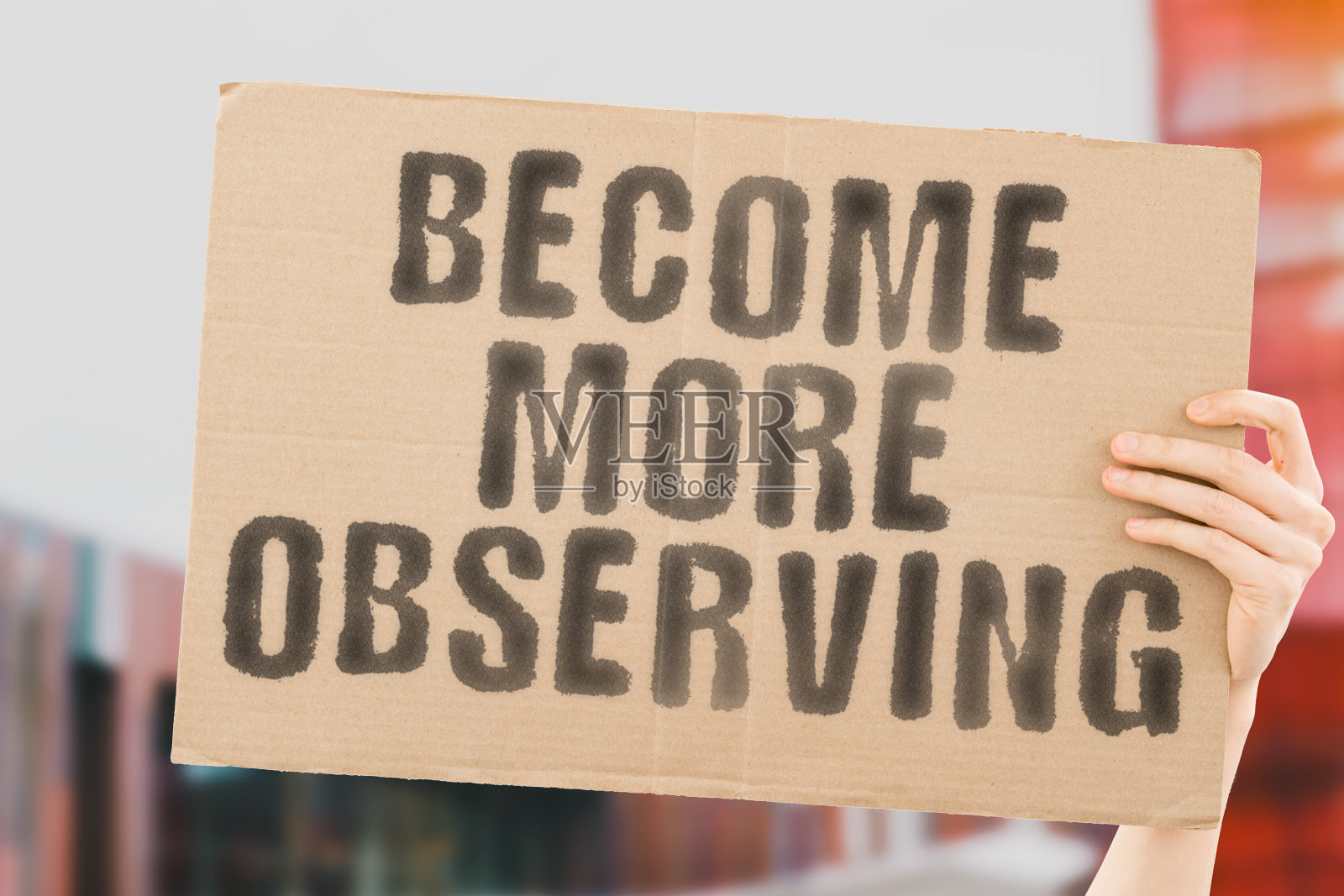 男人手里的横幅上写着“变得更有观察力”，背景模糊。积极的。赚的。忙了。思考。希望。危机。首席执行官。工作。办公室。手表。看。找到。看到的。搜索。的工作。愿景照片摄影图片