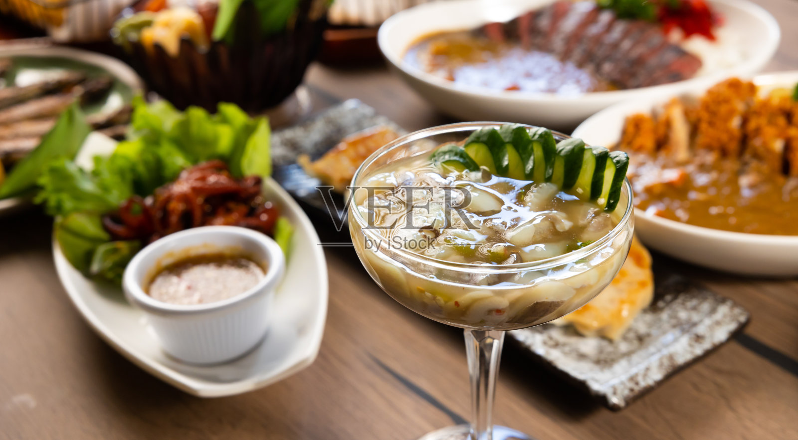 生鱿鱼拌芥末。木桌上摆着许多传统的日本美食。木质背景的日本料理照片摄影图片