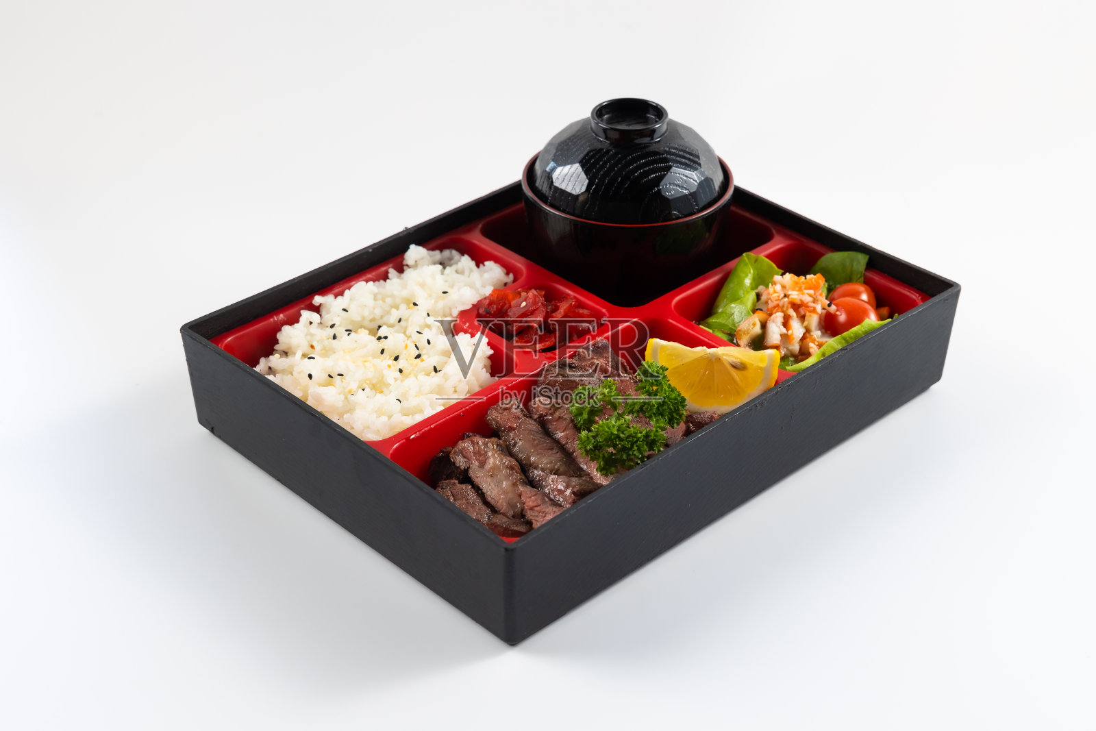 俯视图日本食品便当盒套装与烤牛肉，米饭沙拉和主菜。日本食物被隔离在白色背景上照片摄影图片