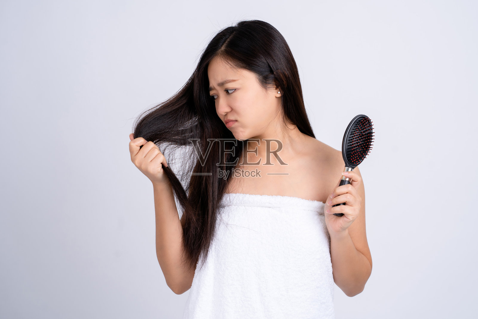 压力年轻的亚洲妇女持有损坏的干燥的头发对双手在白色孤立的背景。照片摄影图片