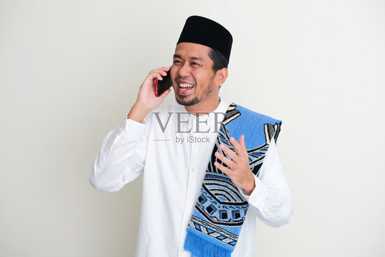 一名亚洲穆斯林男子在斋月庆祝活动期间给家人打电话照片摄影图片