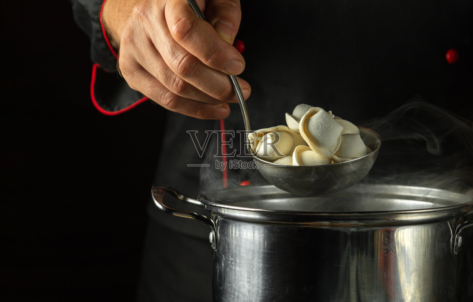 厨师在餐厅厨房的平底锅里准备饺子。厨师工作时的特写镜头照片摄影图片