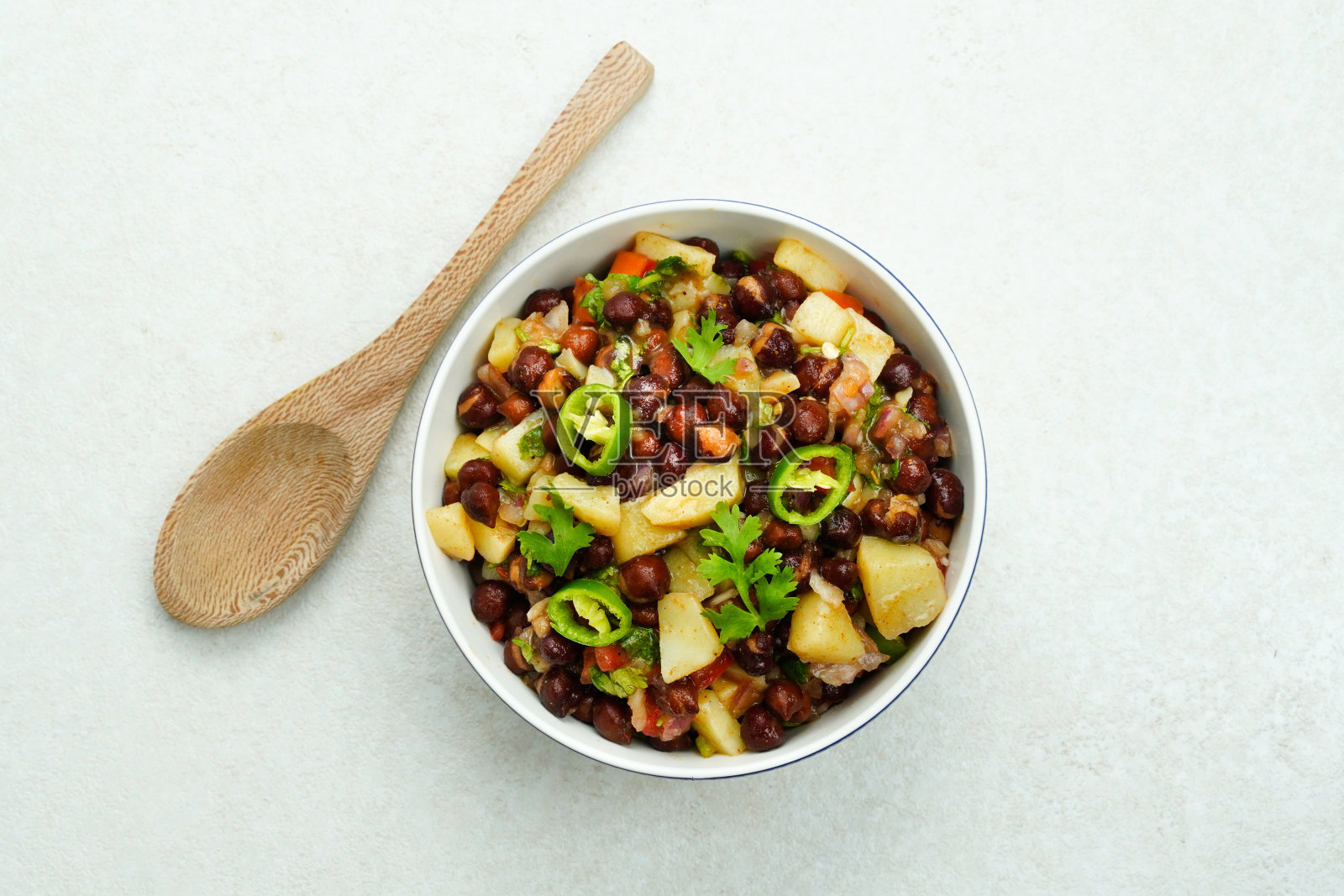 Aloo chana chaat。素食土豆鹰嘴豆小吃。Channa在白碗里聊天照片摄影图片