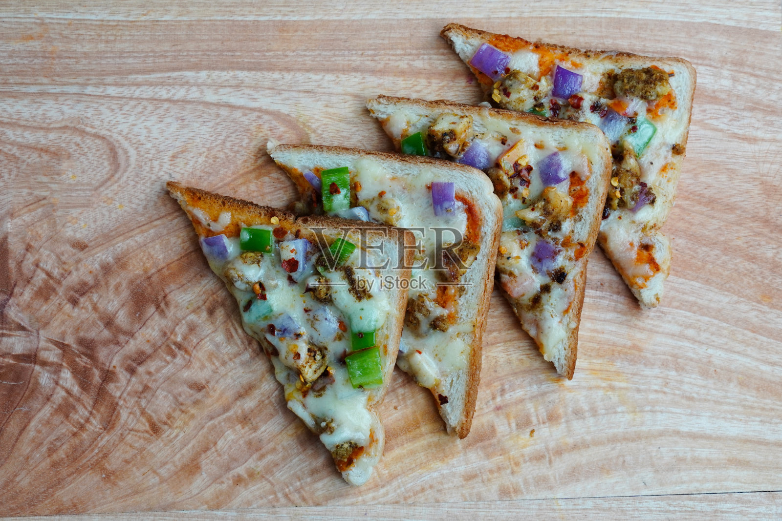 面包披萨或披萨吐司，上面有奶酪、鸡肉和蔬菜照片摄影图片