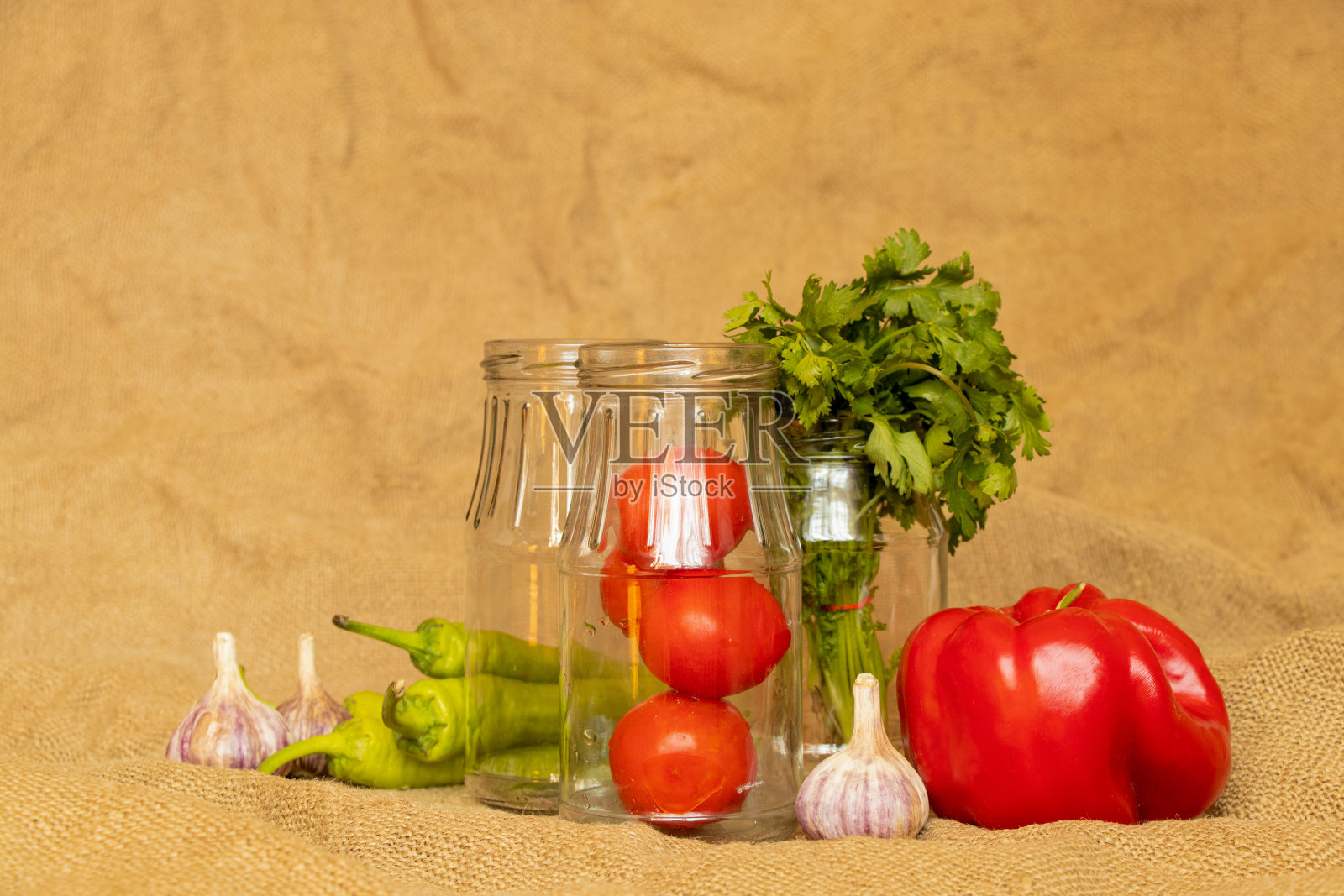 麻袋布上放着辣椒、大蒜、西红柿、辣椒和罐子，为阿吉卡烹饪原料照片摄影图片