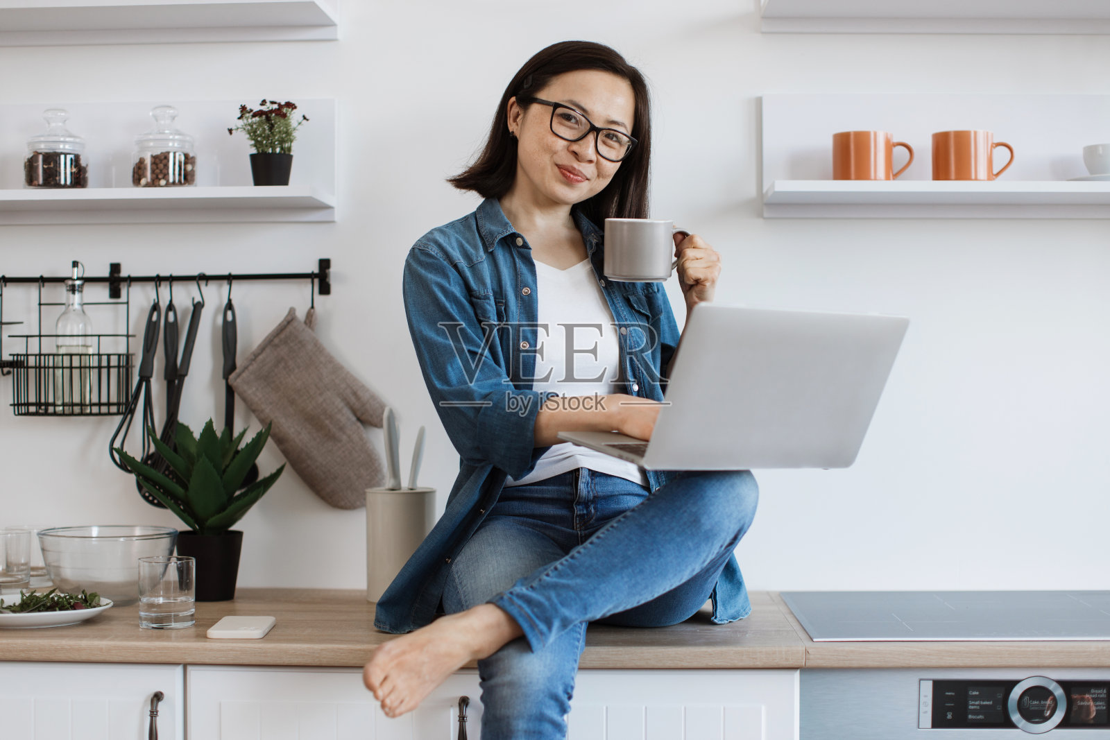 自由职业者一边在家喝茶一边在电脑上打字照片摄影图片