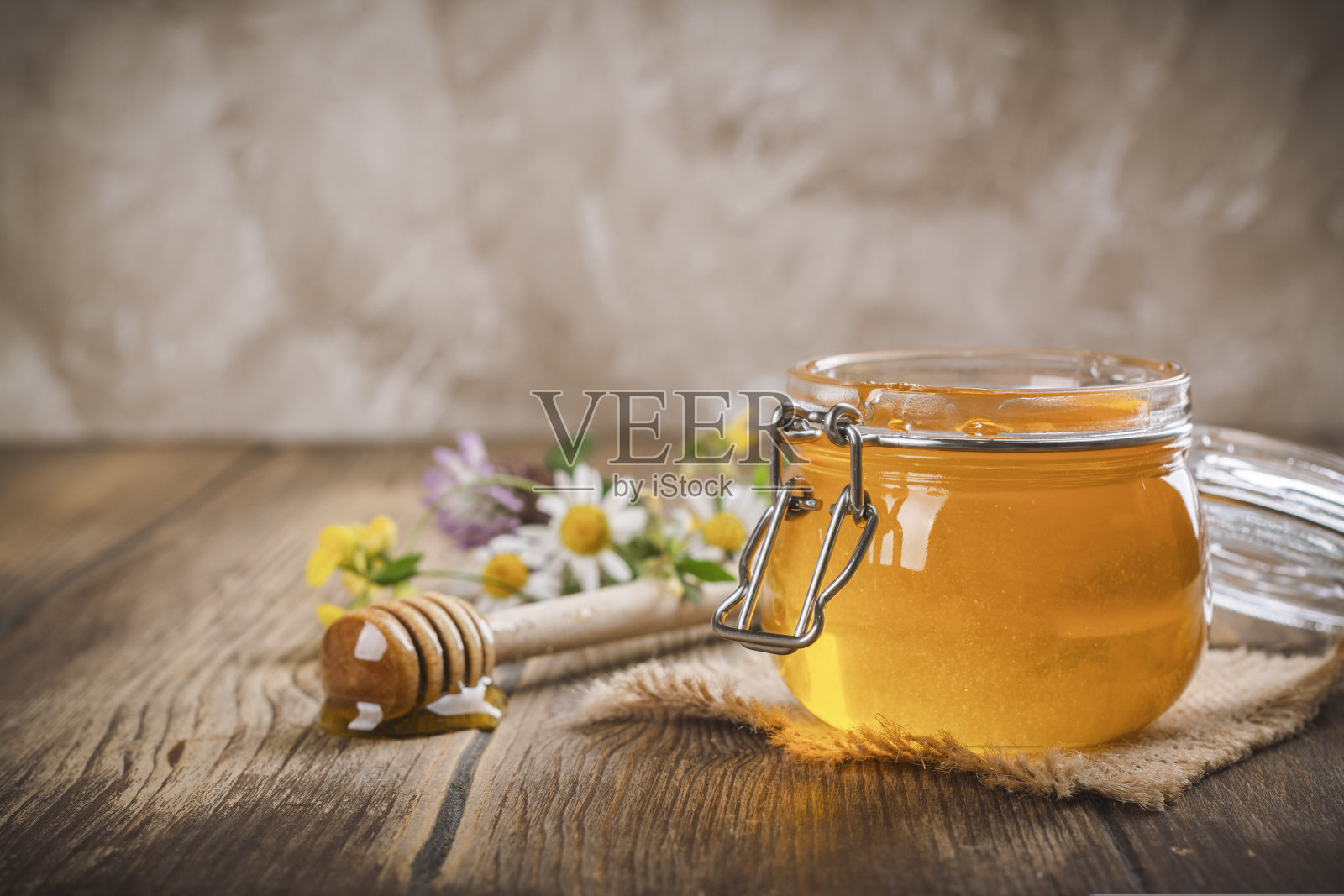 装有花香液体蜂蜜的玻璃罐照片摄影图片