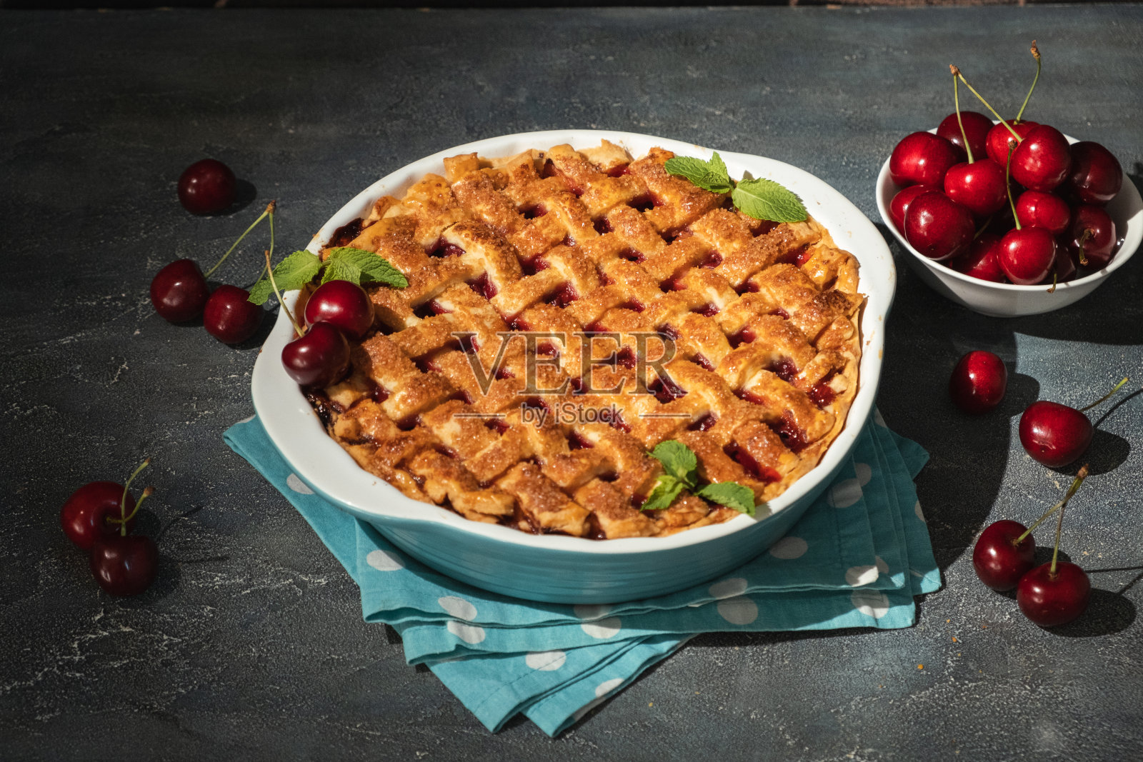 一块美味的自制樱桃派，在灰色的混凝土背景上洒上糖。美国传统的樱桃馅饼。照片摄影图片