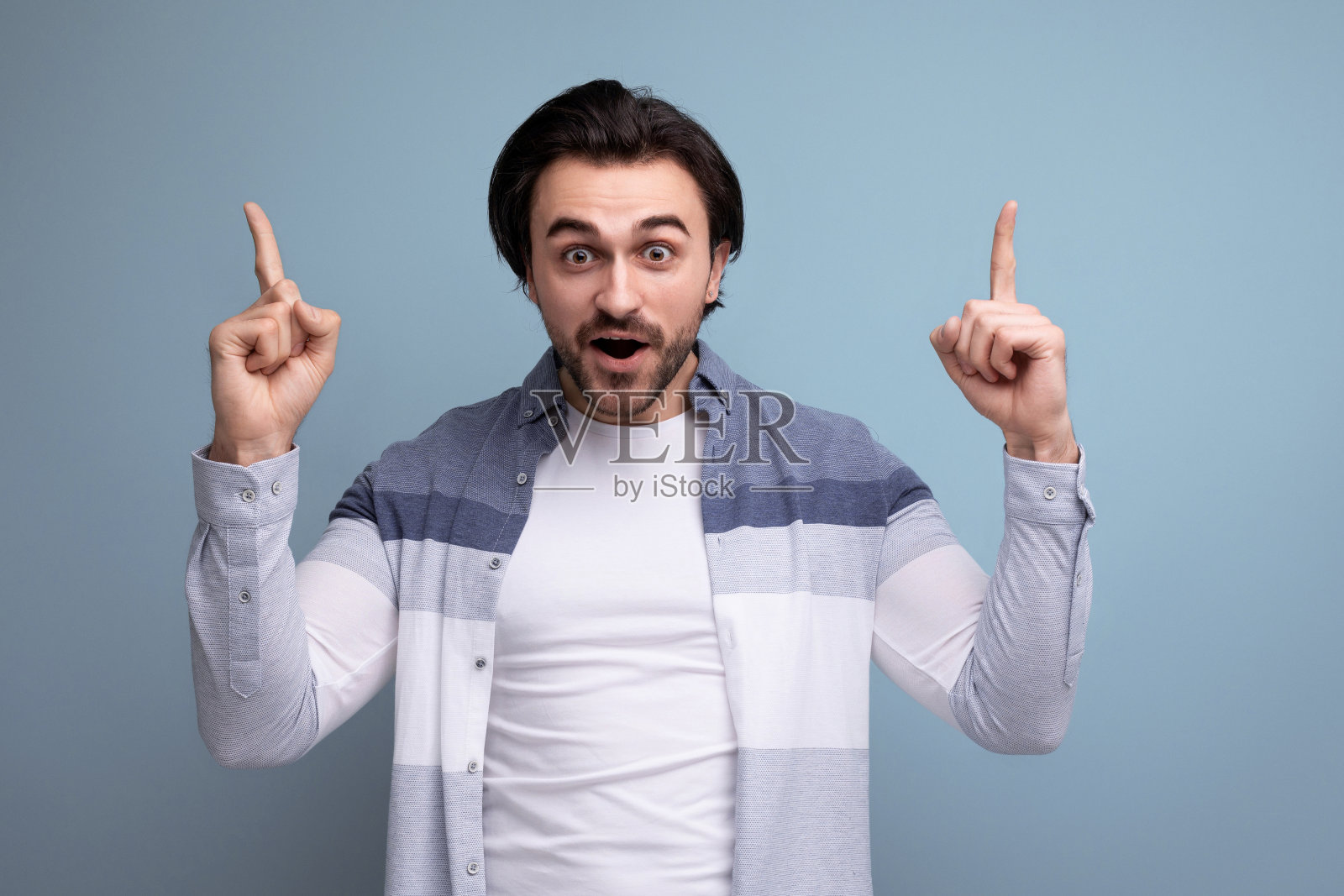 受鼓舞的年轻人用手指着侧面，展示了一个策略的存在照片摄影图片