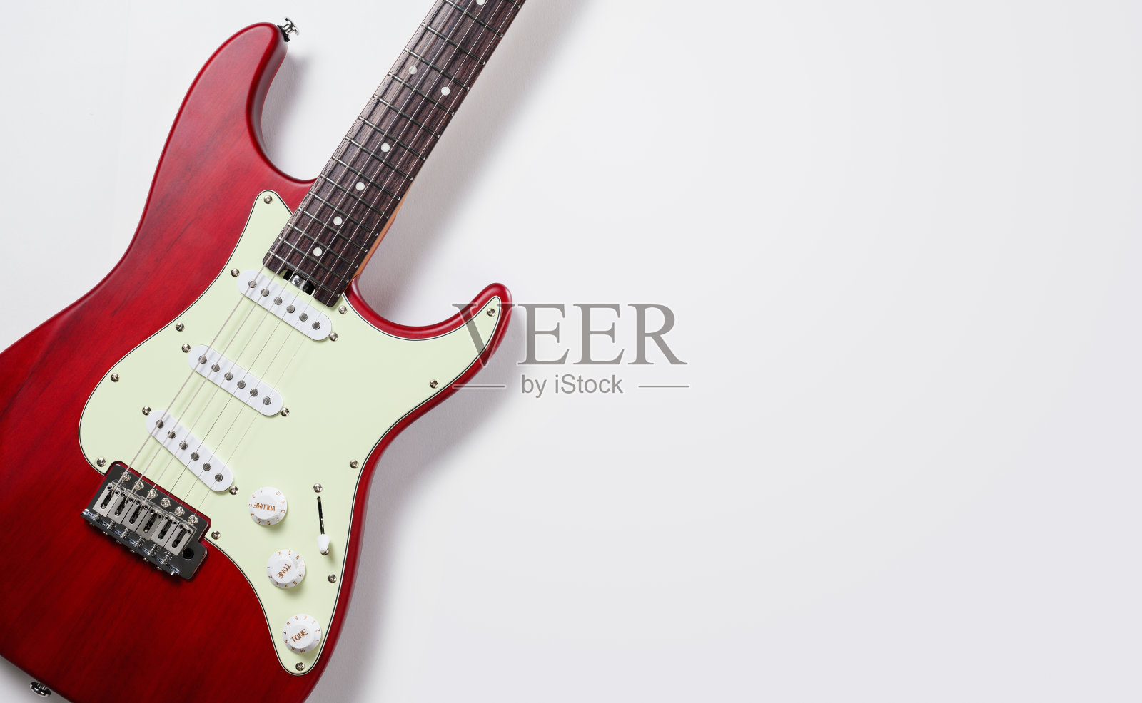 一张红色电吉他的特写，背景是浅色的。文本的自由空间。创意和音乐灵感的概念照片摄影图片