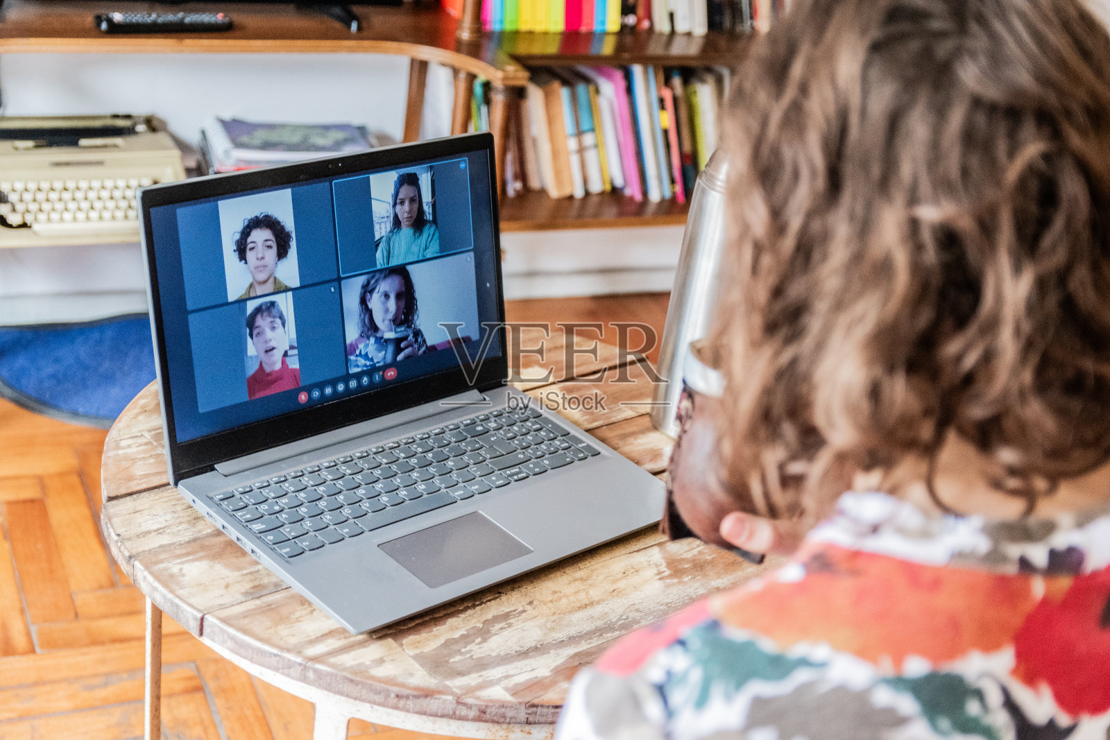 一个女人在家里用笔记本电脑和她的朋友进行视频会议照片摄影图片