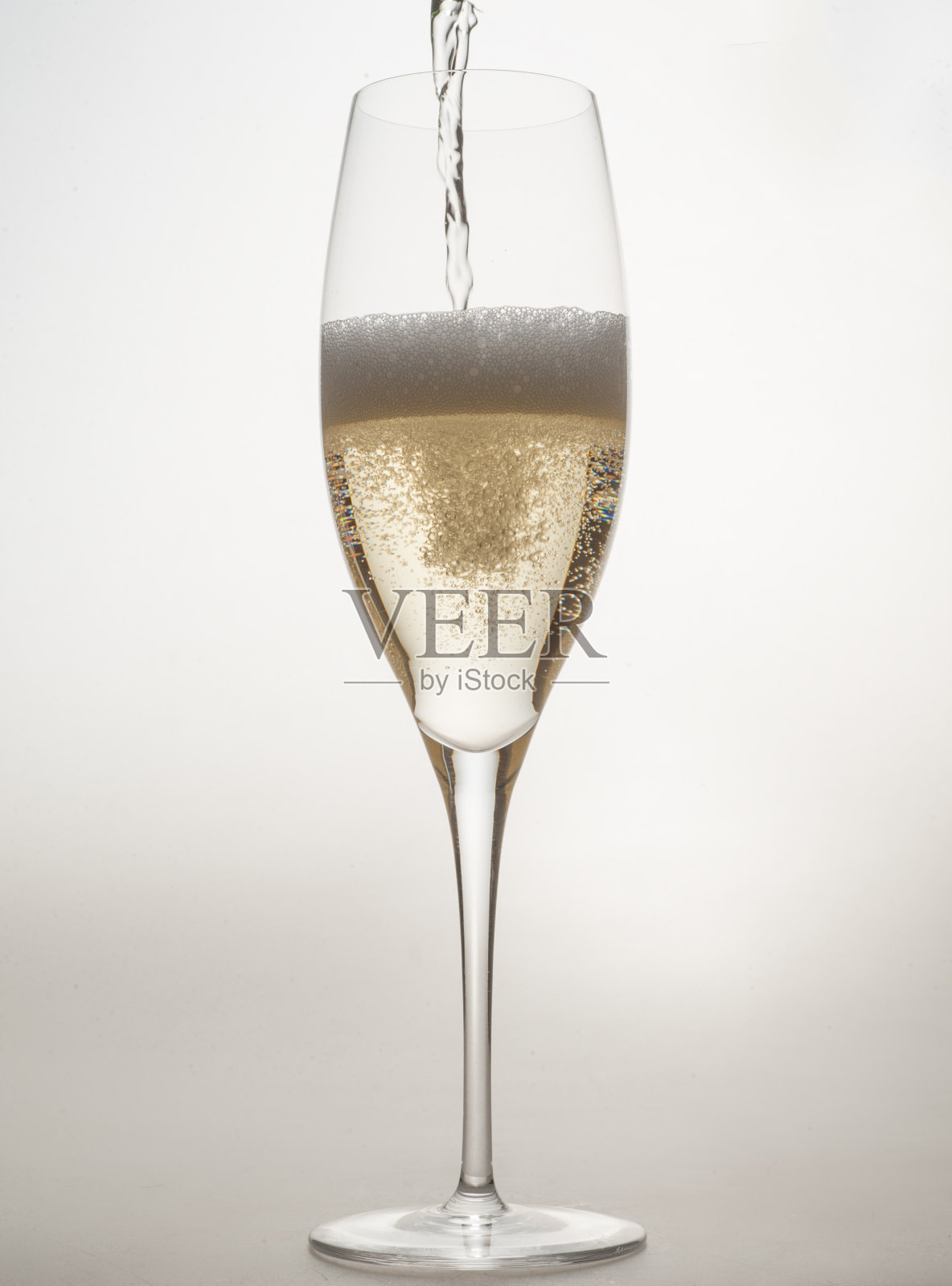 在工作室的灯光背景下，在一个特殊的整体香槟杯中倒入不同形状的香槟气泡照片摄影图片