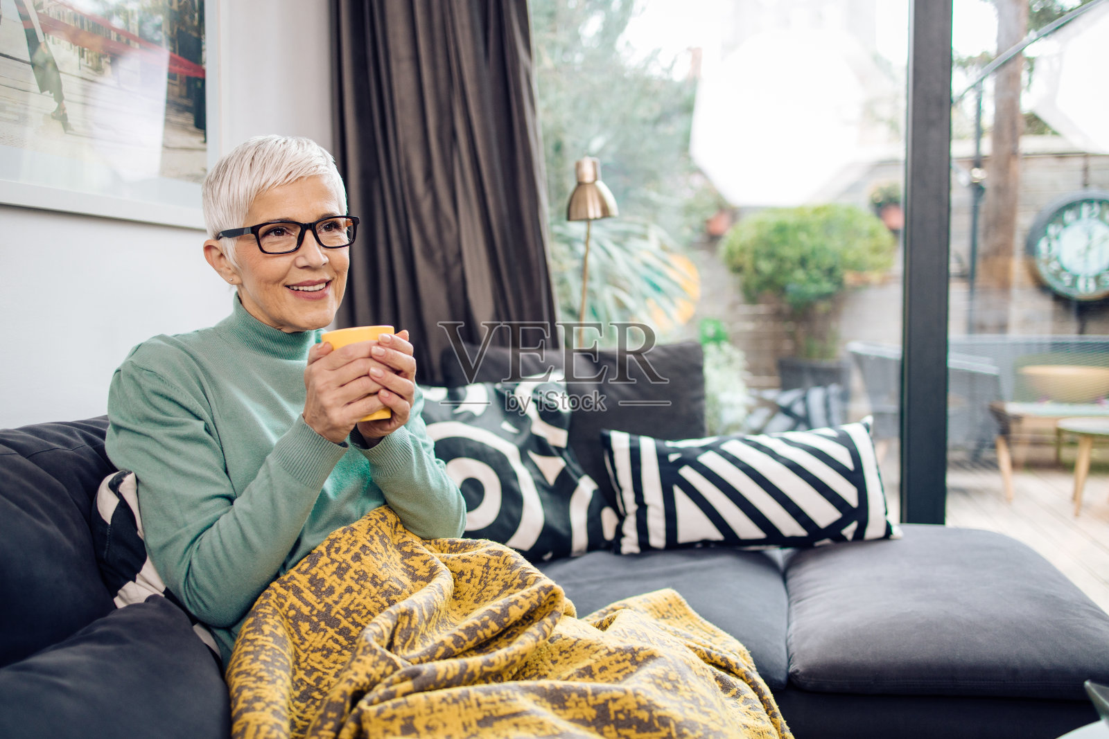 一位快乐的年长妇女享受她的早晨咖啡的肖像照片摄影图片