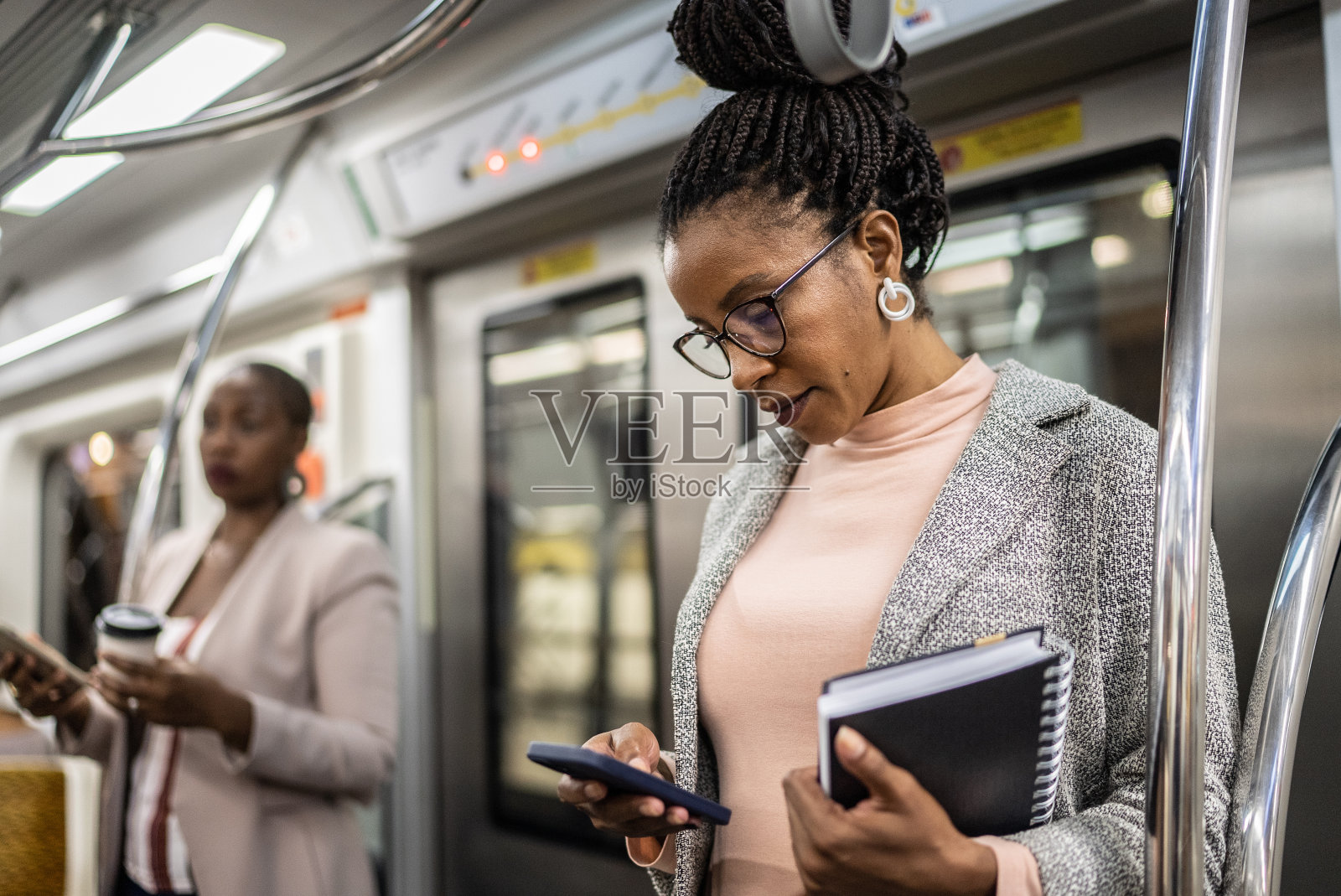 成熟女人在地铁里用手机照片摄影图片