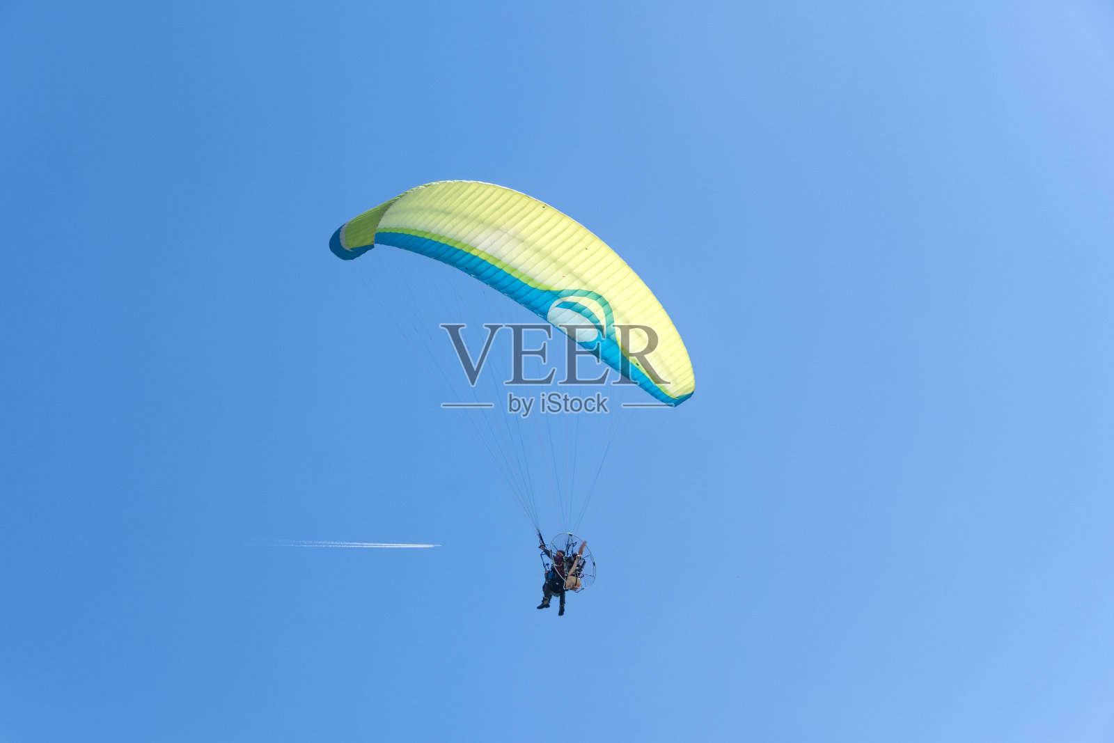 滑翔伞、高空飞行的客机和喷气式客机的飞行轨迹。照片摄影图片