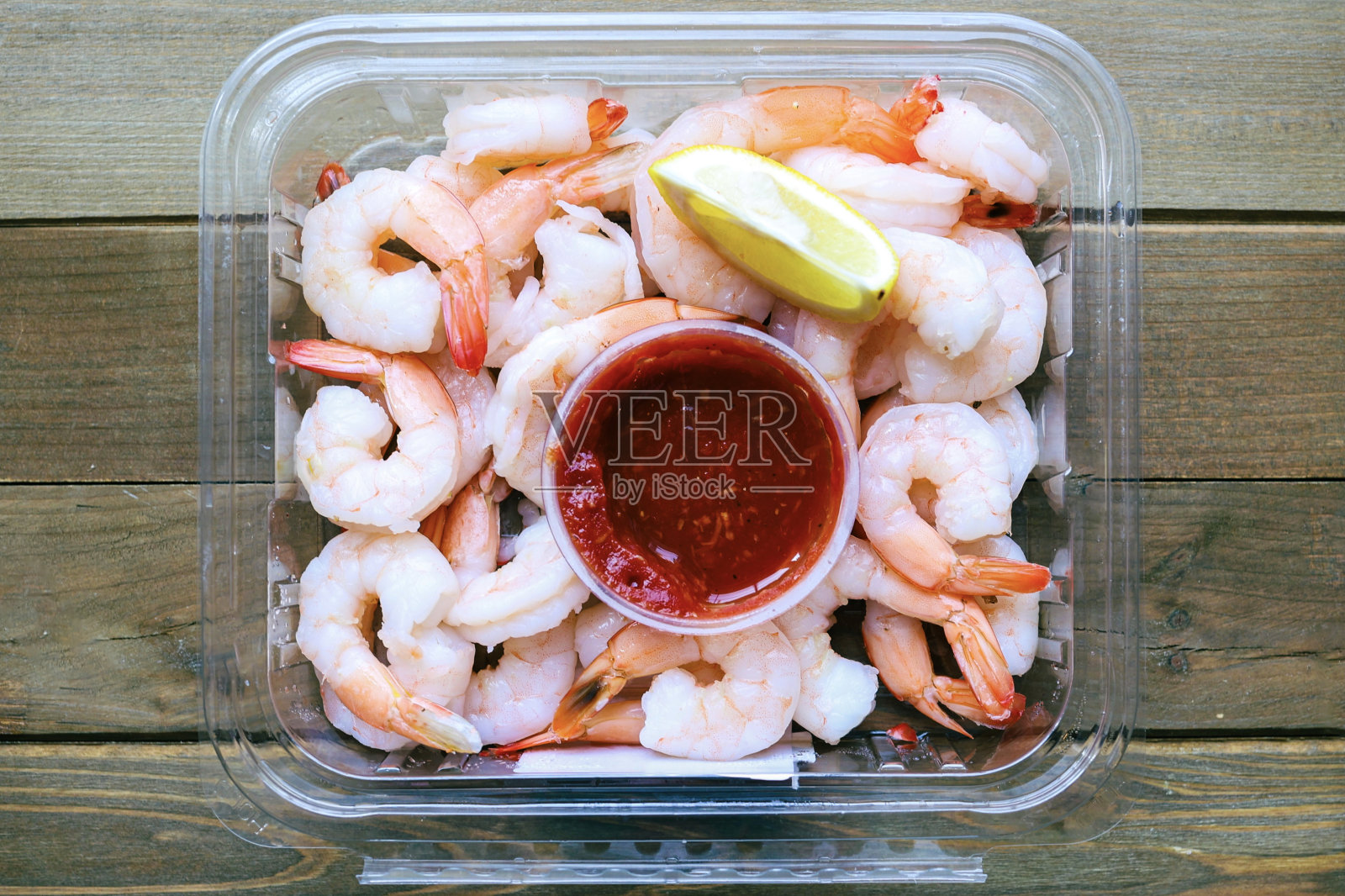 一个装满虾仁鸡尾酒和酱汁的塑料容器照片摄影图片