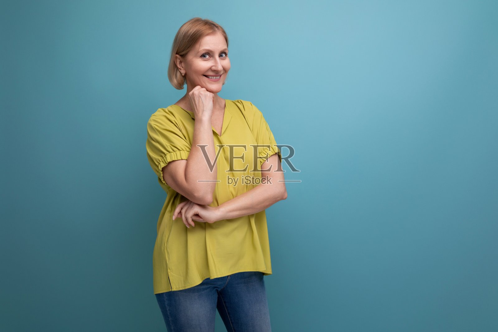 金发中年女子在影楼背景与影印空间上表现出欢快的情绪照片摄影图片