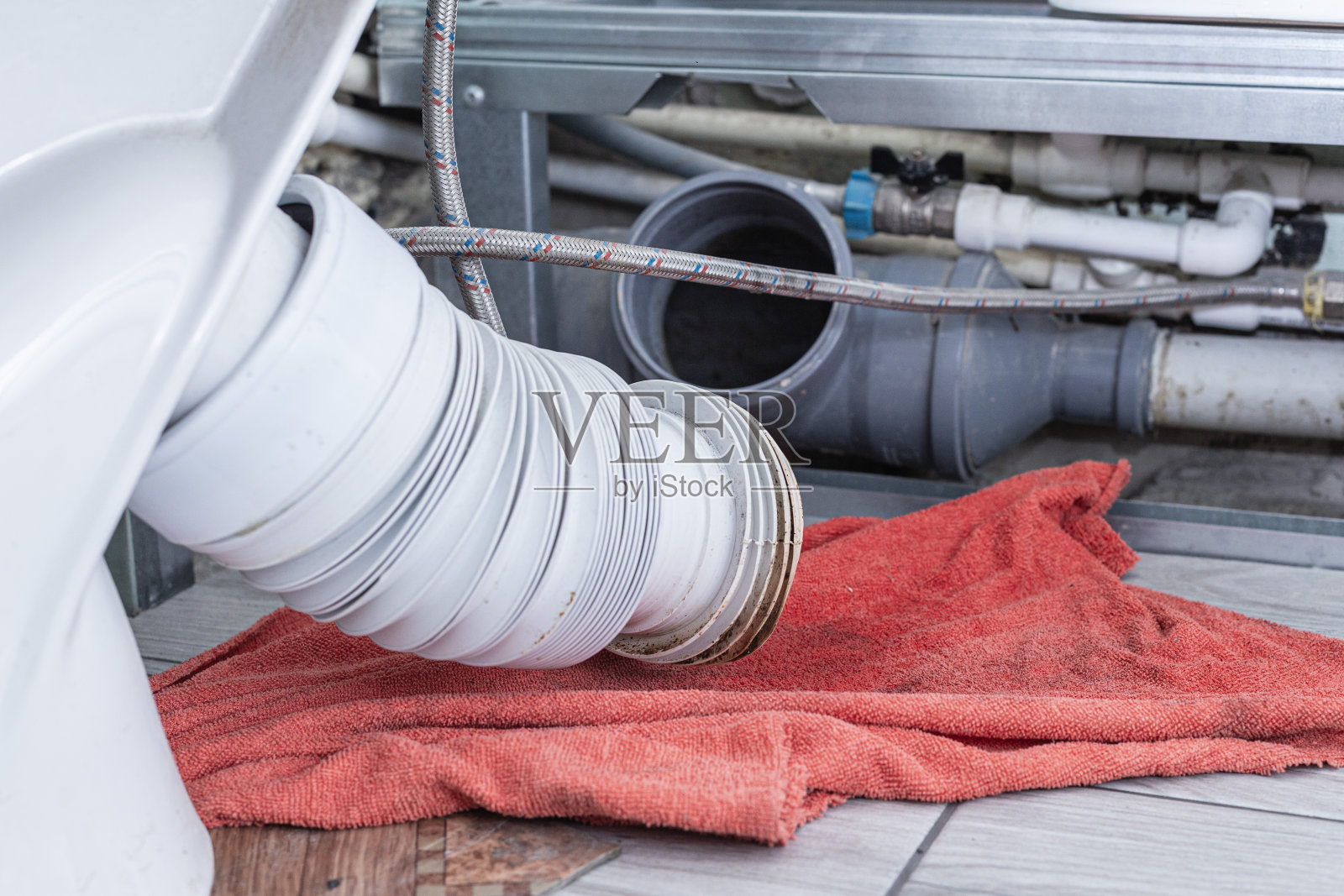 陶瓷老旧的白色马桶在修理一个冲水装置时特写，背景被模糊了，带有散景效果照片摄影图片