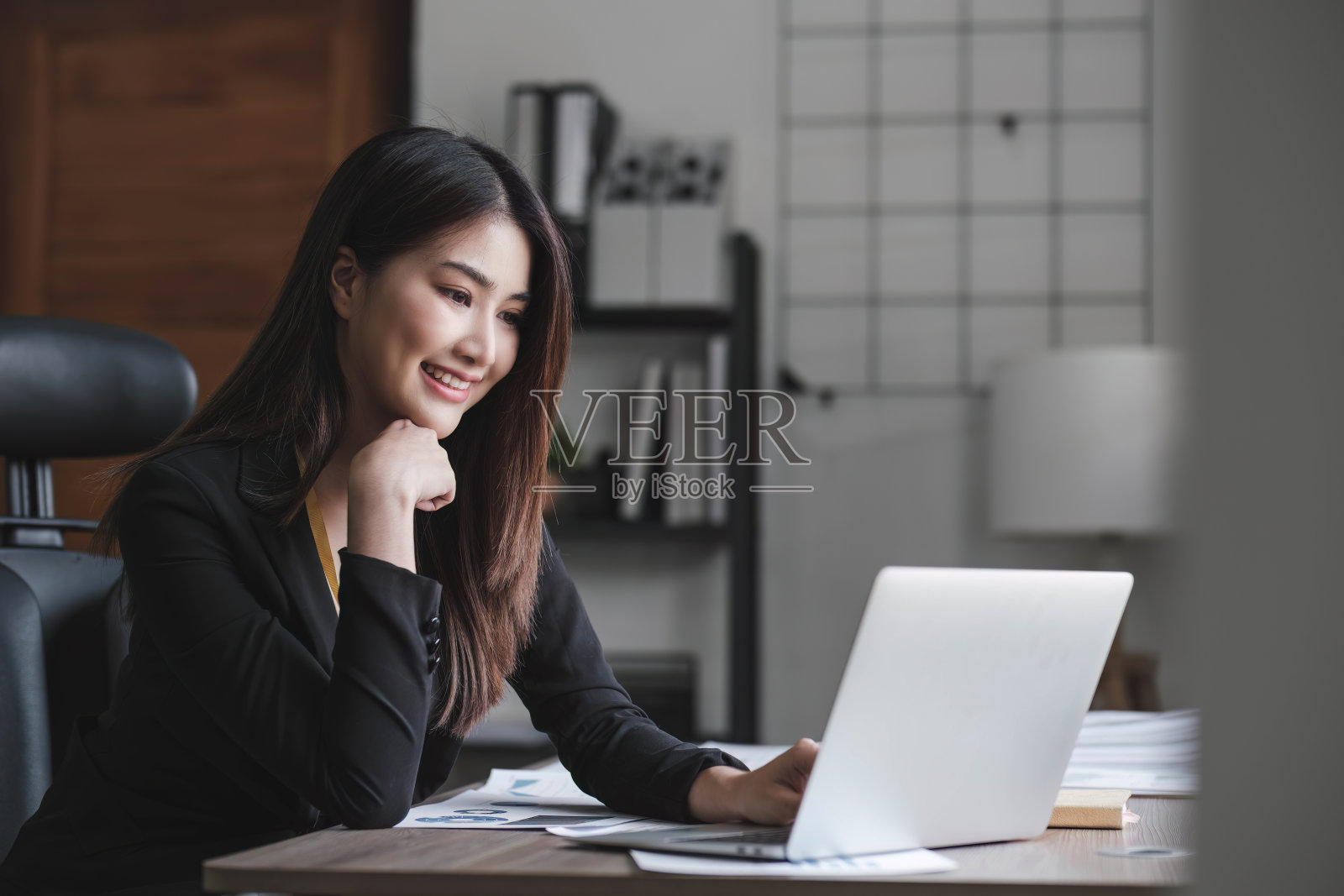 商务女性使用计算器在办公室的木桌上做数学、财务和商务工作背景，税务、会计、统计和分析研究概念。照片摄影图片