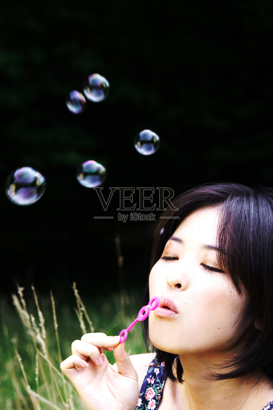 年轻的亚洲女人吹泡泡的领域照片摄影图片