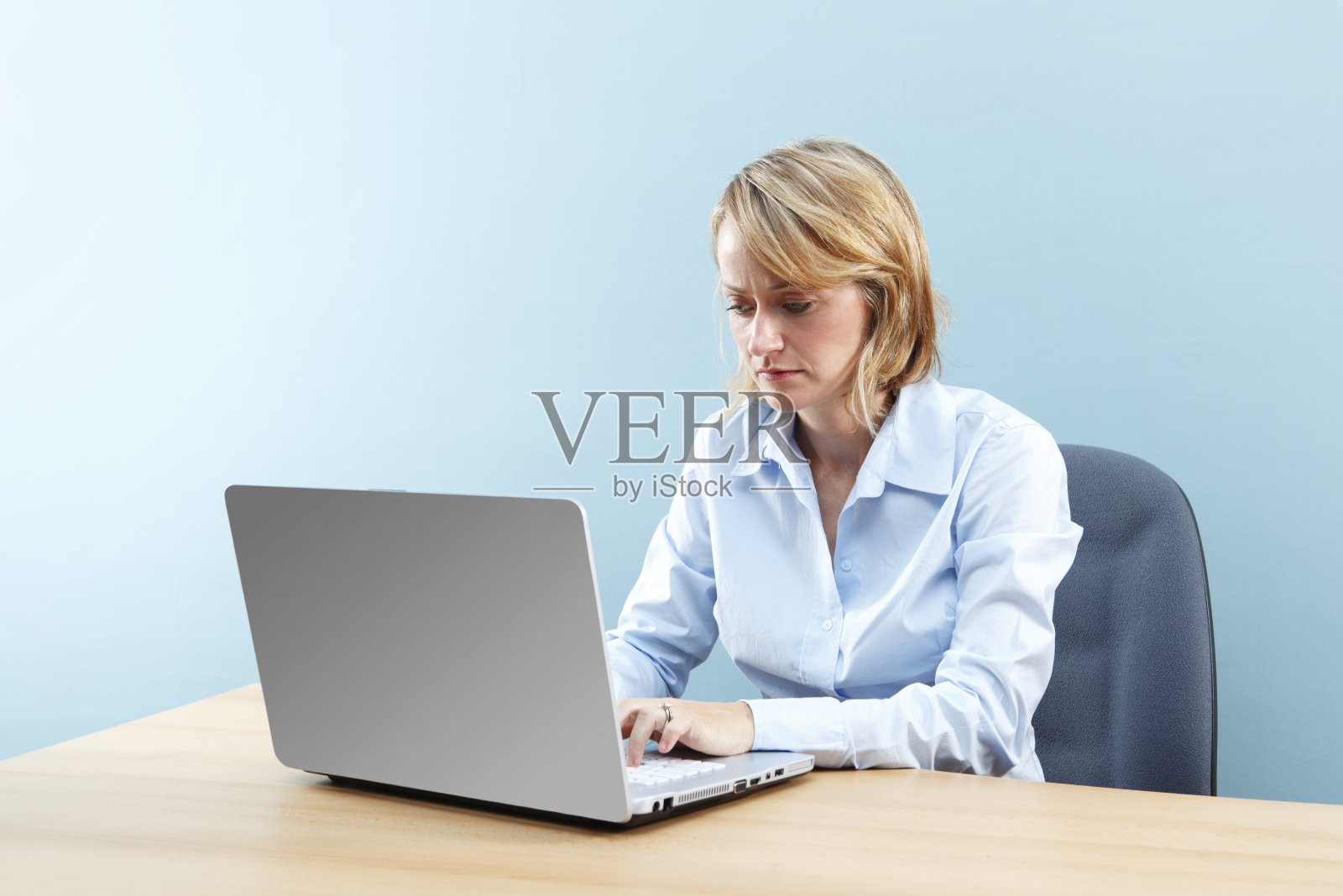 笔记本电脑上的严肃女人照片摄影图片