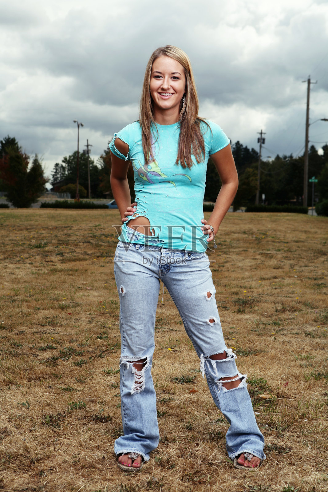 金发女孩摆姿势双手放在臀部照片摄影图片