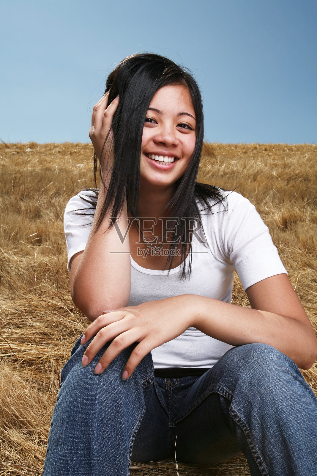 坐在田野里微笑的亚洲女人照片摄影图片