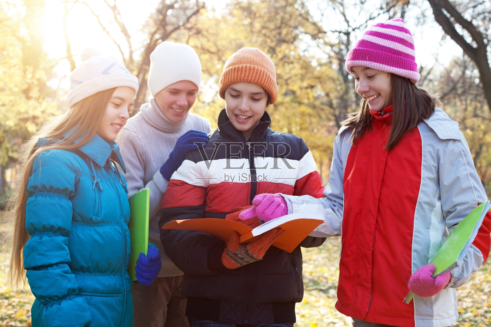 愉快的孩子们在公园里看书。照片摄影图片
