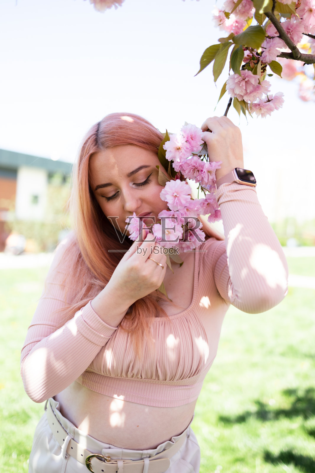 春天的象征，女孩在花园里欣赏盛开的樱花。春天开花。温柔和女性气质。樱桃树。照片摄影图片
