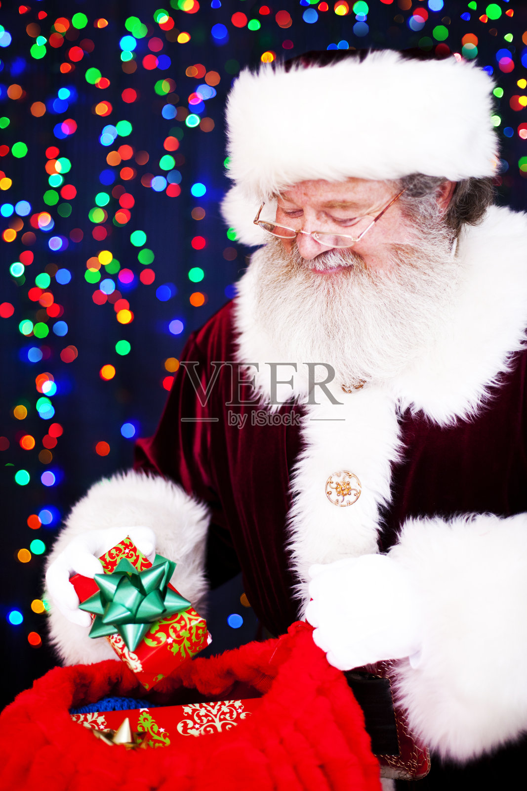 圣诞老人在看一袋礼物照片摄影图片